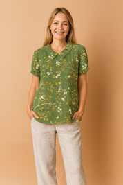 Donkergroene linnen blouse met korte mouwen, versierd met goudgele takken en witte bloesems in een sierlijk geborduurd patroon.