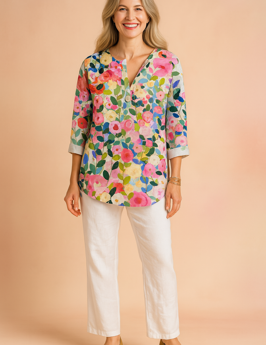 Linnen blouse met driekwartmouwen en kleurrijke bloemenprint in roze, groen, geel en blauw op een lichte ondergrond. Voorzien van halve knoopsluiting en rechte zoom.
