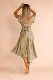 Lichtgroene midi-jurk met korte vlindermouwen, diepe V-hals, gedraaide taille met sleutelgat cut-out en vloeiende asymmetrische zoom.