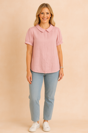 Roze blouse met Peter Pan-kraag, korte pofmouwen en een glad geweven linnenlook stof zonder patroon.