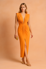 Model draagt een elegante mouwloze oranje avondjurk met diepe V-hals en geplooid detail aan de voorkant, perfect voor formele gelegenheden.