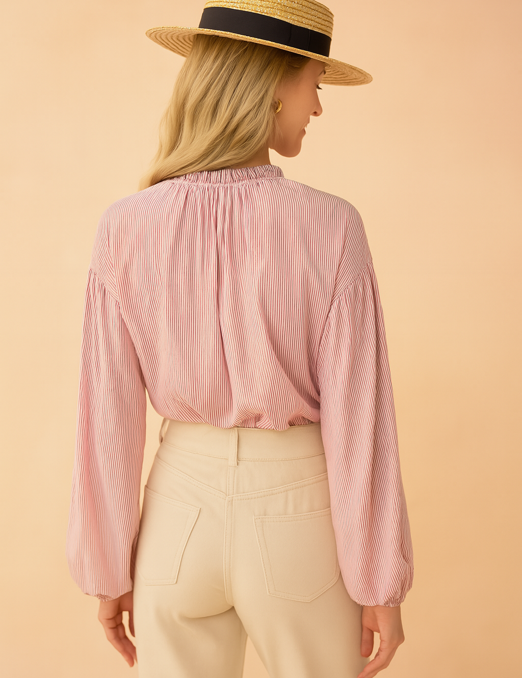 Roze damesblouse met subtiele verticale streepstructuur, gemaakt van een luchtige geweven stof. Voorzien van lange ballonmouwen met elastische manchetten, knoopsluiting aan de voorkant en een opstaand rufflekraagje met keyhole-detail. De losvallende pasvorm zorgt voor een vrouwelijke en stijlvolle uitstraling.