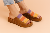 Opvallende kleurrijke platform sleehak sandalen met bruine lederen look en bandjes in geel, oranje en violet—stijlvol en comfortabel voor warme dagen.